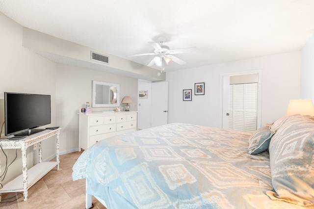 tiled bedroom featuring ceiling fan and a closet