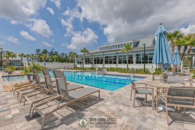 pool with a patio area and fence