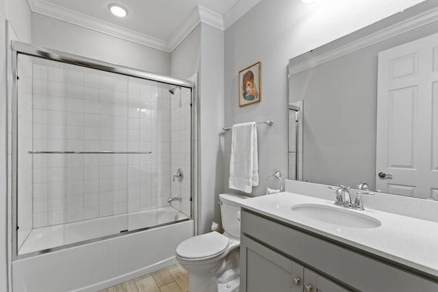 bathroom with crown molding, vanity, toilet, wood finished floors, and bath / shower combo with glass door