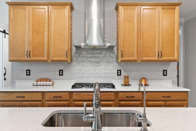 kitchen featuring crown molding, light countertops, decorative backsplash, and wall chimney exhaust hood