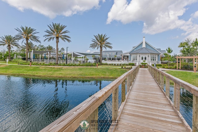 dock area with a lawn and a water view