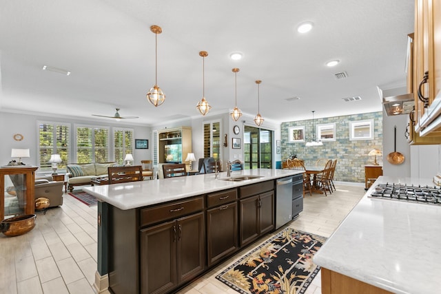 kitchen featuring visible vents, open floor plan, ceiling fan, a sink, and appliances with stainless steel finishes