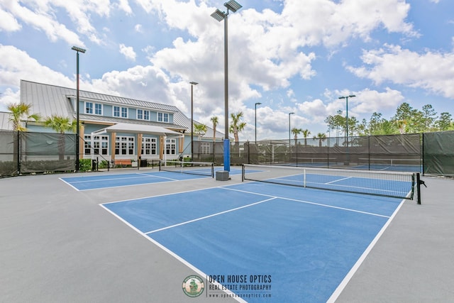 view of tennis court featuring community basketball court and fence