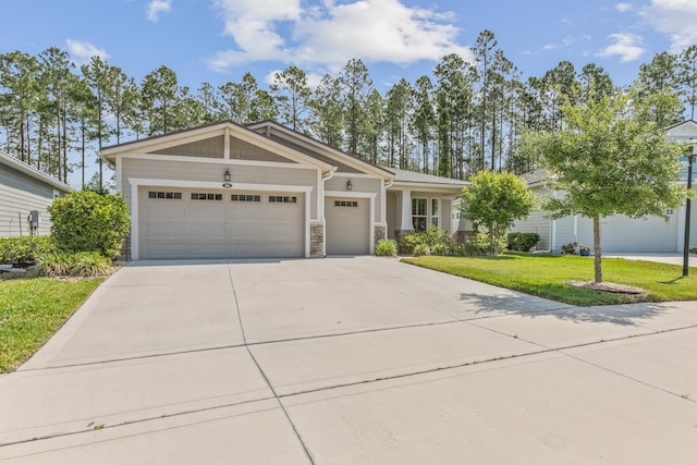 view of front of house with a garage, driveway, stone siding, and a front lawn