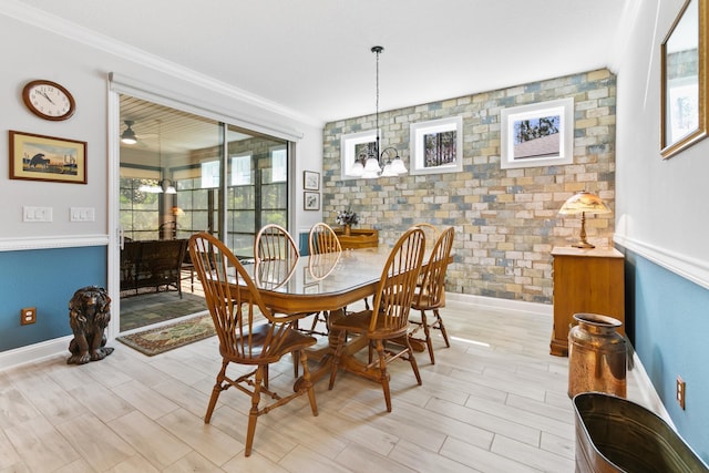 dining area with light wood-style floors, baseboards, ornamental molding, and a wealth of natural light