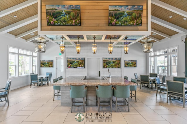 interior space featuring light tile patterned flooring, beamed ceiling, and a chandelier