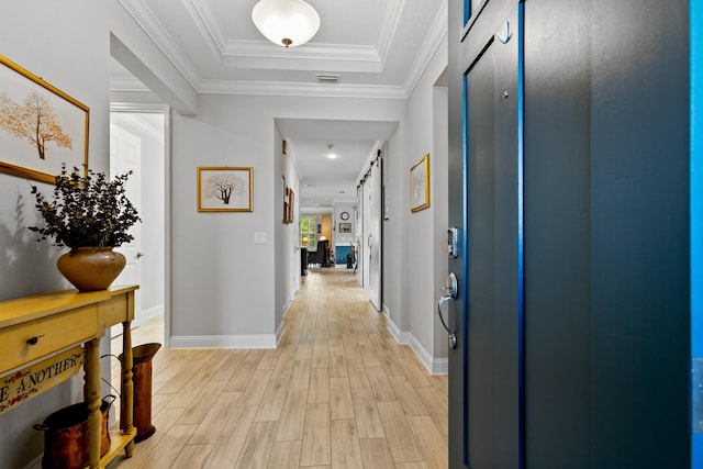 hall featuring baseboards, visible vents, a raised ceiling, and light wood-style floors
