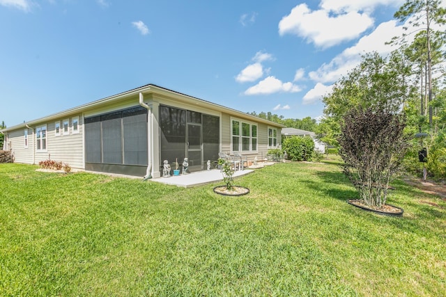 rear view of house featuring a lawn and a sunroom