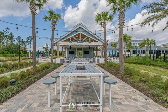view of community featuring fence, outdoor dining space, and a patio area