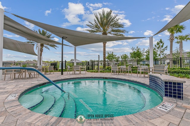 view of swimming pool featuring a patio, fence, outdoor dining space, and a pool