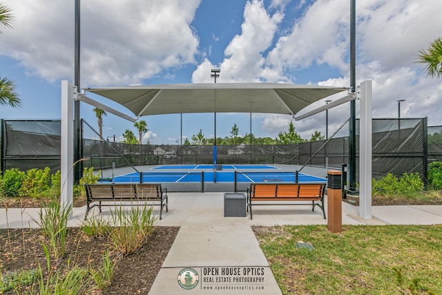 view of pool with a tennis court and fence