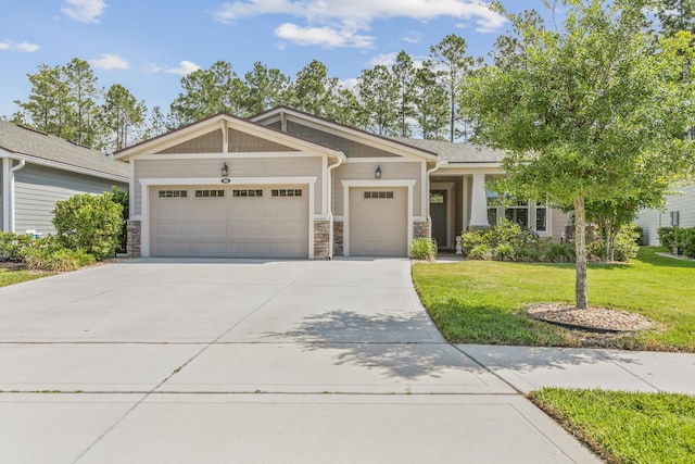 craftsman house featuring an attached garage, concrete driveway, a front lawn, and stone siding