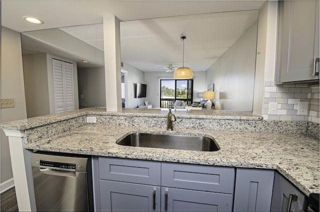 kitchen featuring tasteful backsplash, gray cabinetry, sink, and stainless steel dishwasher