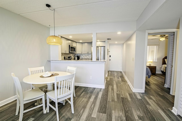 dining area featuring a textured ceiling, ceiling fan, and dark wood-type flooring