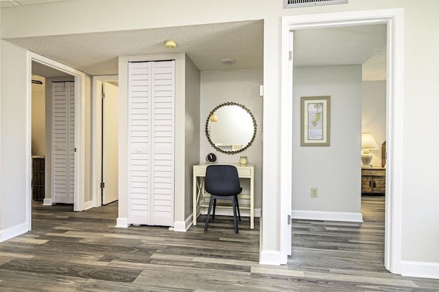 hallway featuring dark hardwood / wood-style flooring and a textured ceiling