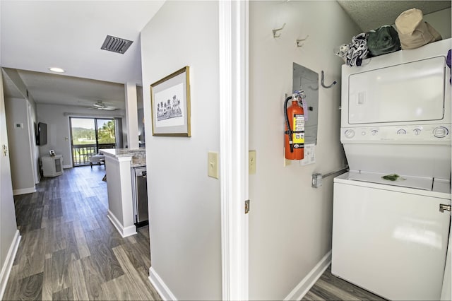 washroom with stacked washer and dryer, ceiling fan, and dark wood-type flooring