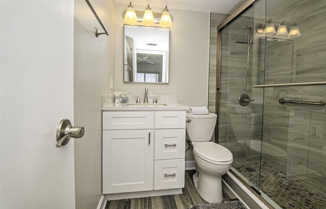 bathroom with hardwood / wood-style floors, vanity, toilet, and an enclosed shower