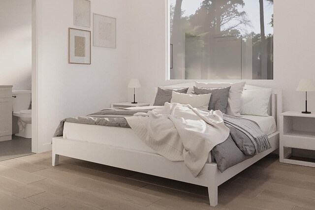 bedroom with connected bathroom and light wood-type flooring