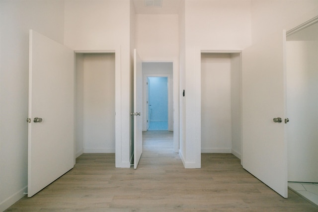 hallway with light hardwood / wood-style floors