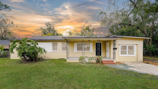 ranch-style house featuring a front yard and covered porch