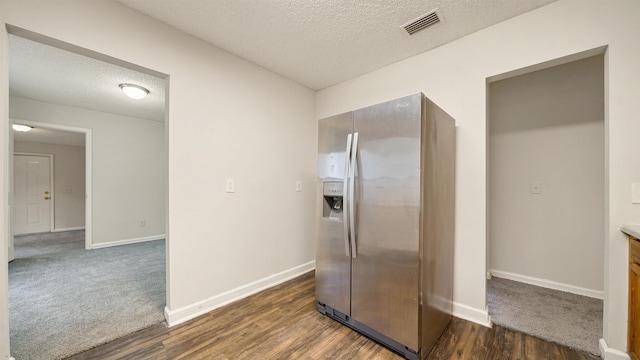 bathroom with visible vents, a textured ceiling, baseboards, and wood finished floors