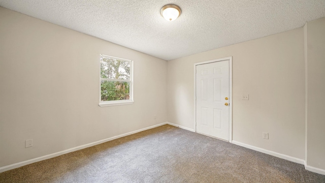 empty room featuring carpet flooring, a textured ceiling, and baseboards