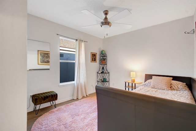 bedroom with wood finished floors, baseboards, and ceiling fan