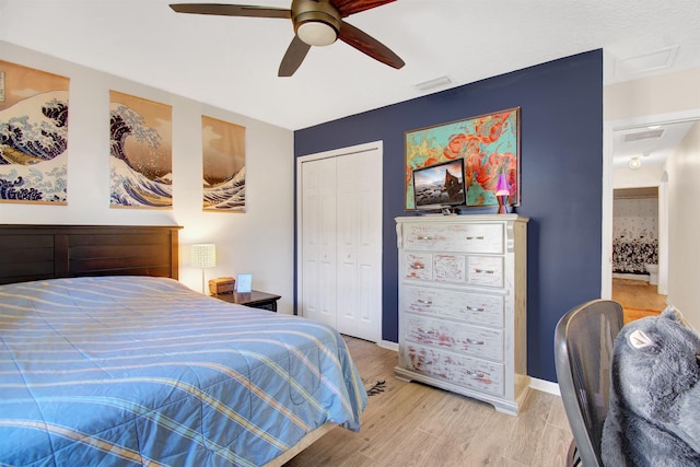 bedroom with light wood-style floors, a closet, ceiling fan, and baseboards