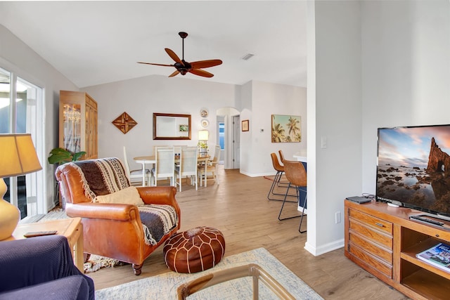 living room featuring arched walkways, ceiling fan, wood finished floors, lofted ceiling, and baseboards