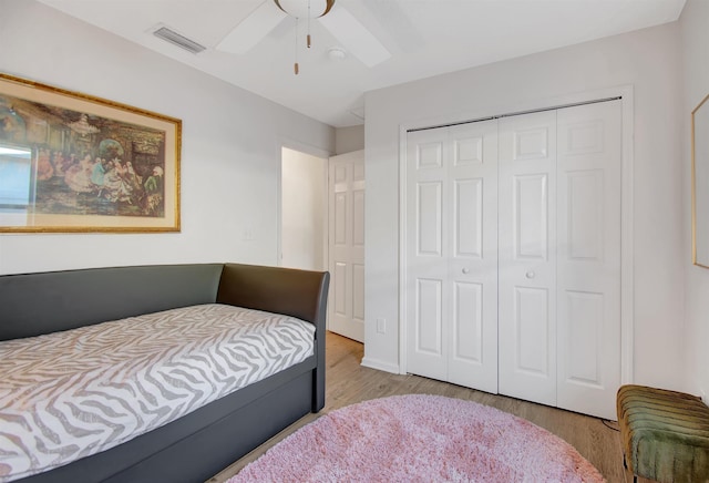bedroom with a closet, wood finished floors, and a ceiling fan