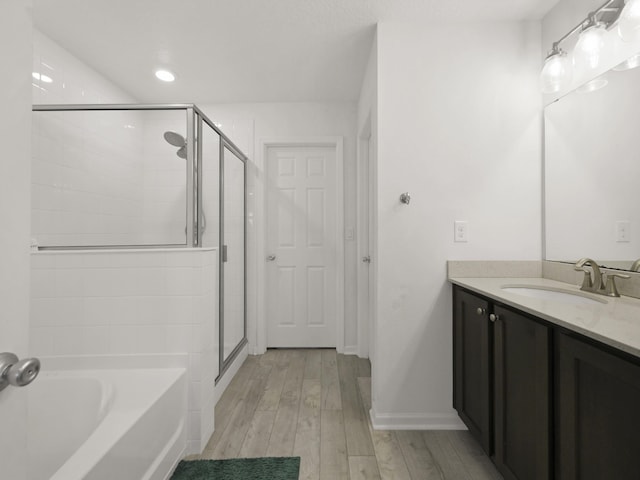 bathroom featuring separate shower and tub, vanity, and hardwood / wood-style flooring