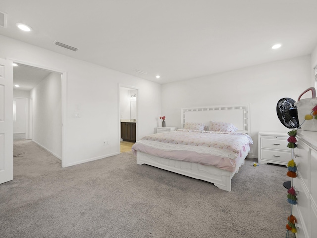 bedroom featuring light carpet and ensuite bathroom