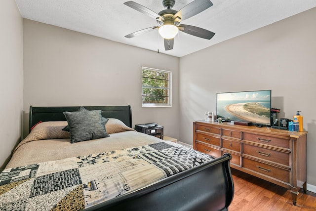 bedroom featuring a textured ceiling, ceiling fan, and hardwood / wood-style floors