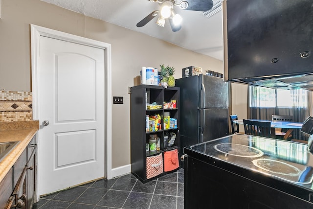 kitchen with dark tile patterned floors, black appliances, backsplash, ventilation hood, and ceiling fan