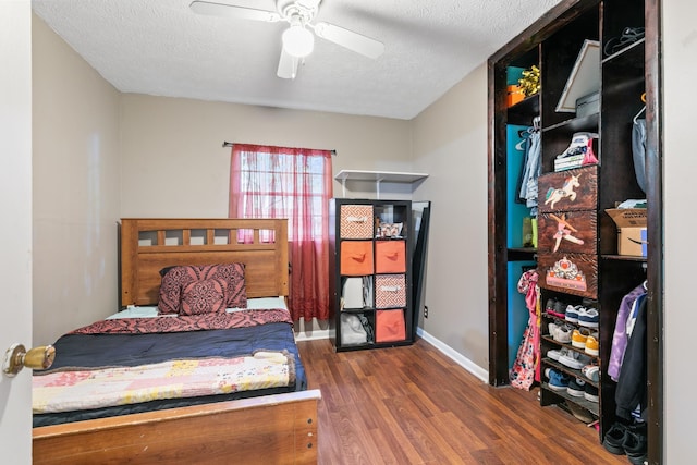 bedroom featuring ceiling fan, dark hardwood / wood-style flooring, and a textured ceiling