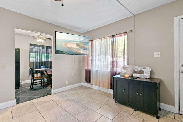 interior space with ceiling fan and light tile patterned flooring