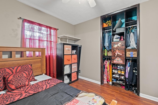 bedroom with ceiling fan, a closet, a textured ceiling, and hardwood / wood-style floors