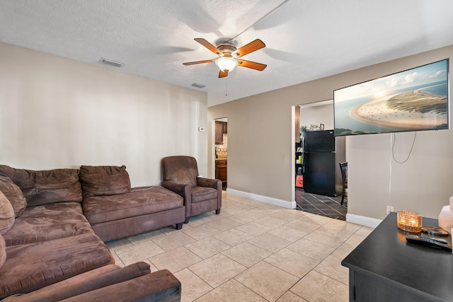 tiled living room with ceiling fan and a textured ceiling