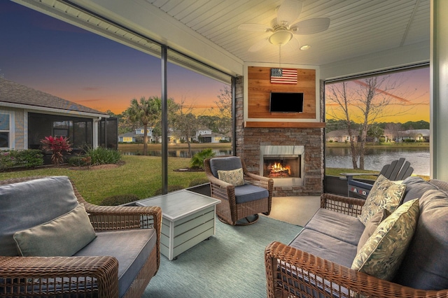 sunroom / solarium with an outdoor stone fireplace and ceiling fan