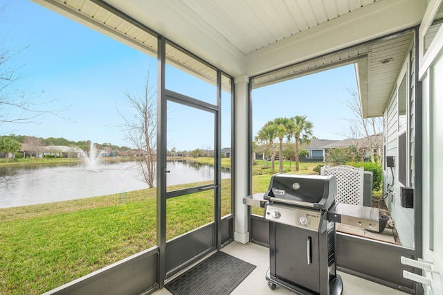 sunroom featuring a healthy amount of sunlight and a water view