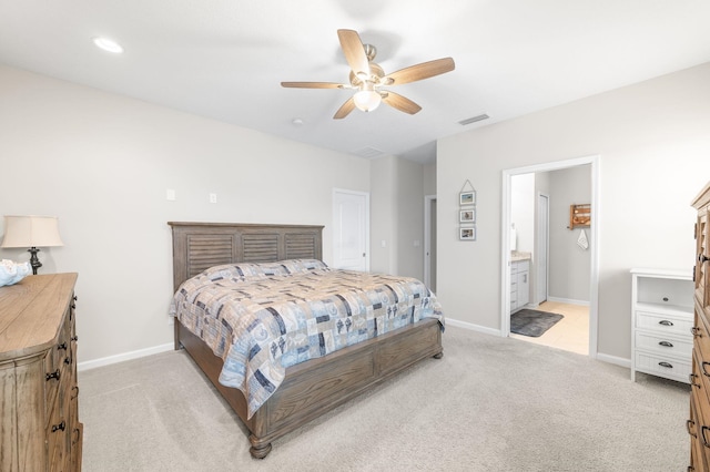 bedroom featuring baseboards, visible vents, ensuite bathroom, and light carpet