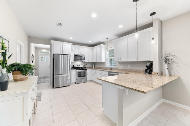 kitchen featuring visible vents, a peninsula, white cabinets, stainless steel appliances, and a sink