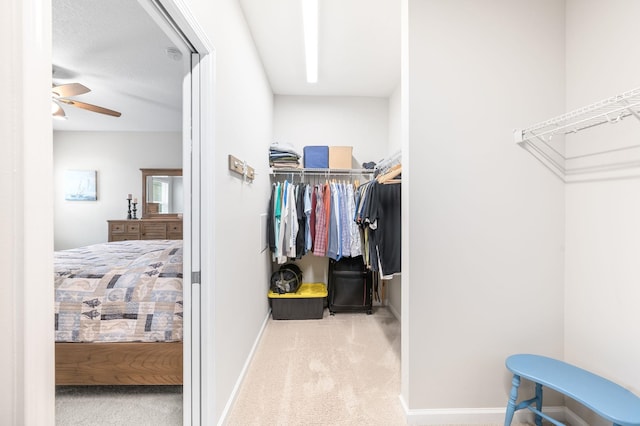 walk in closet with carpet flooring and a ceiling fan