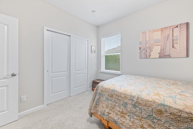 bedroom with a closet, baseboards, and carpet