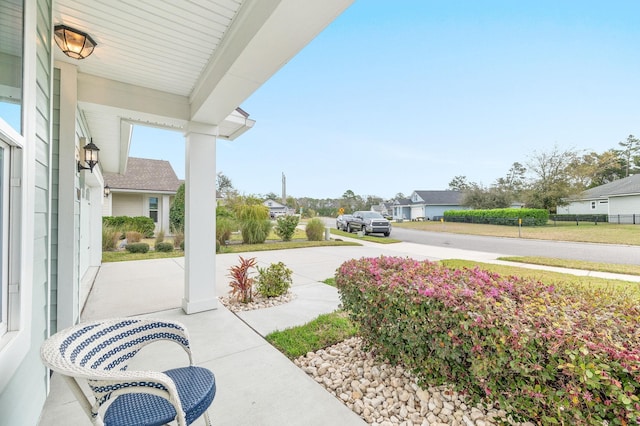 view of patio with a residential view, covered porch, and driveway