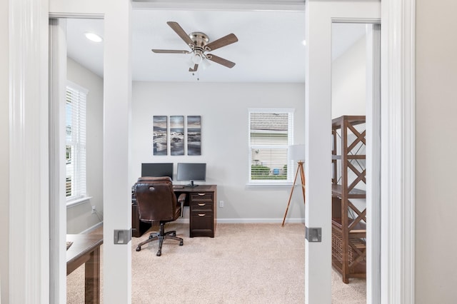 carpeted home office with baseboards and a ceiling fan