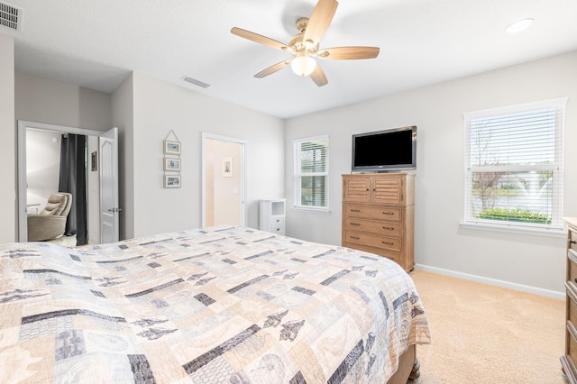 bedroom with visible vents, light colored carpet, baseboards, and multiple windows