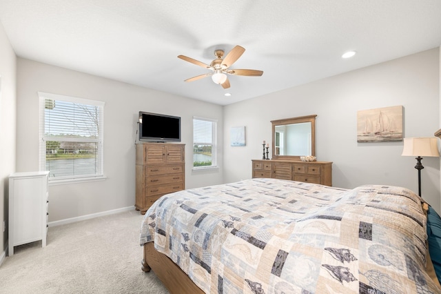 bedroom featuring light carpet, recessed lighting, multiple windows, and baseboards