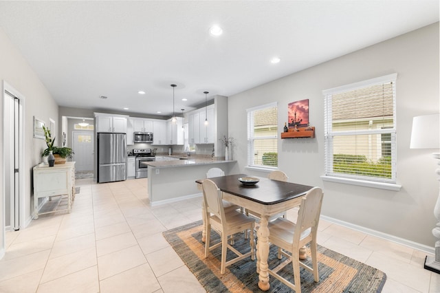 dining room with light tile patterned floors, recessed lighting, and baseboards