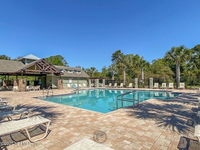 community pool featuring a patio and fence